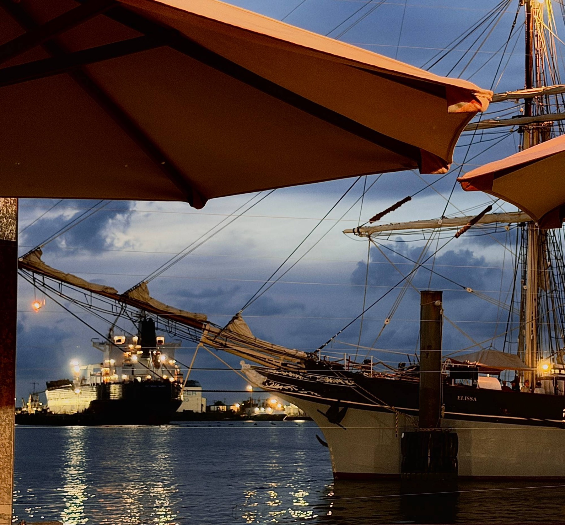 Elissa at dusk, through the umbrellas