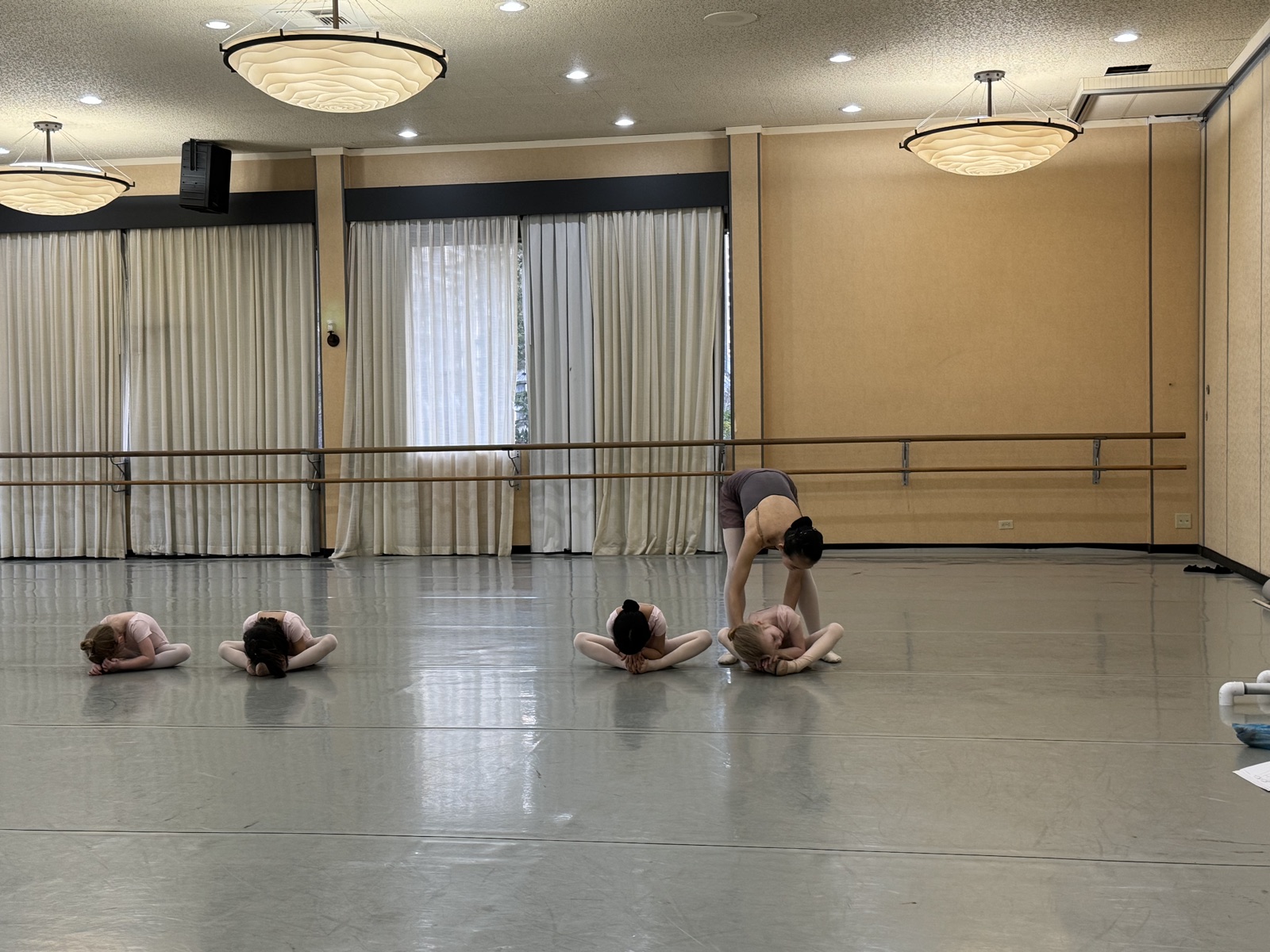 Adjusting a young dancer's stretch in class
